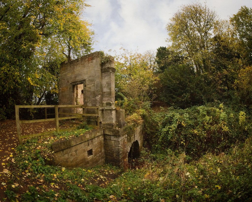 Historic stone ruins surrounded by autumn foliage and greenery.